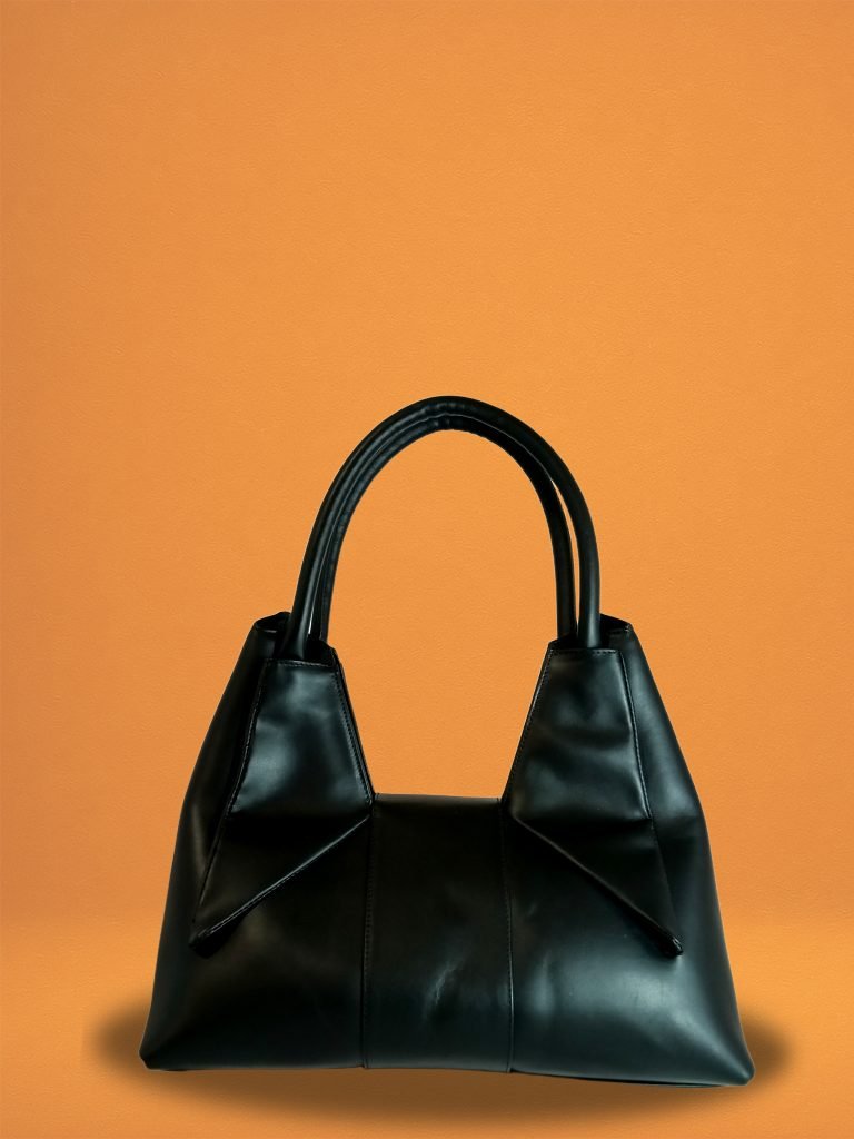 Back view of the Black Italian leather Miacontessa Dea handbag featuring a unique origami style geometric, folded design.