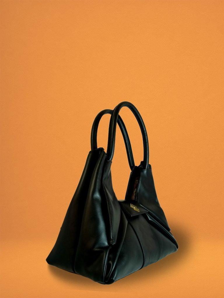 Side view of the Black Italian leather Miacontessa Dea handbag featuring a unique origami style geometric, folded design.