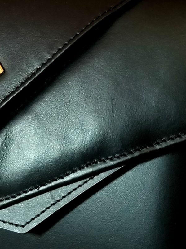 Closeup view of the Miacontessa origami style Intramontabile handbag in obsidian black Italian leather, featuring its structured silhouette and unique folded detailing.