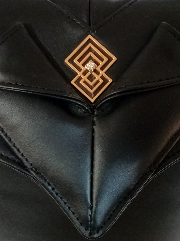 Closeup view of Miacontessa Amore origami style handbag in obsidian black Italian leather, highlighting its unique, folded design that creates an illusionary or artful aesthetic.