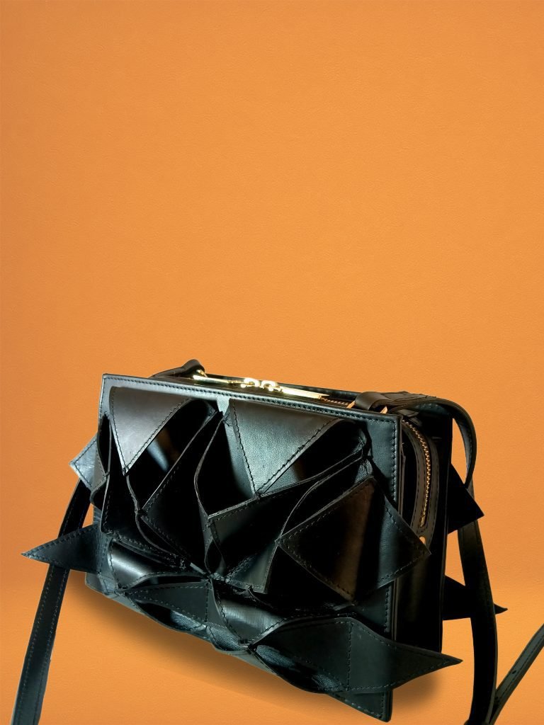 Side view of Miacontessa Arte origami style handbag in obsidian black Italian leather, highlighting its unique, folded design that creates an illusionary or artful aesthetic.