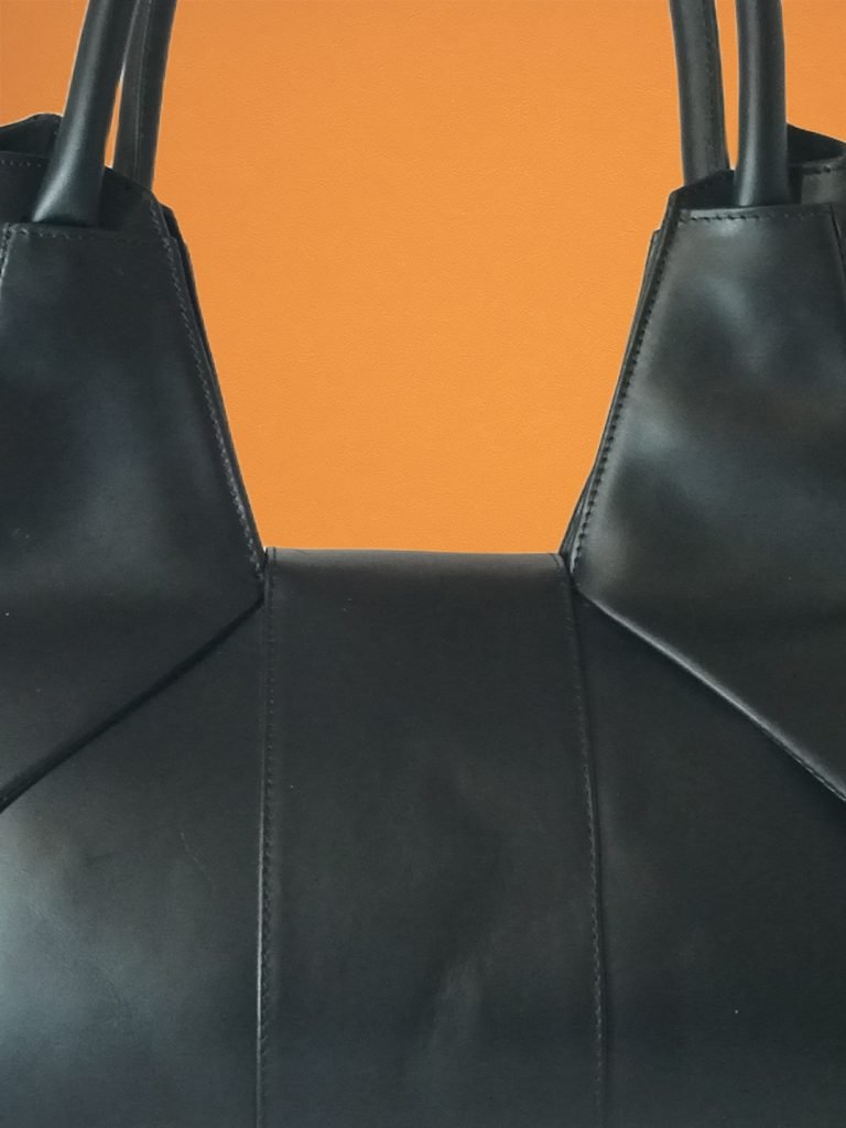 closeup view of Black Italian leather Miacontessa Dea handbag featuring a unique origami style geometric, folded design.