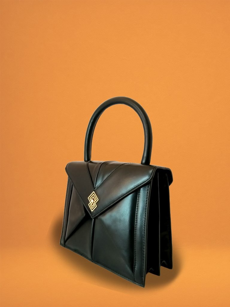 Side view of Miacontessa Magia origami style handbag in obsidian black Italian leather, highlighting its unique, folded design that creates an illusionary or artful aesthetic.
